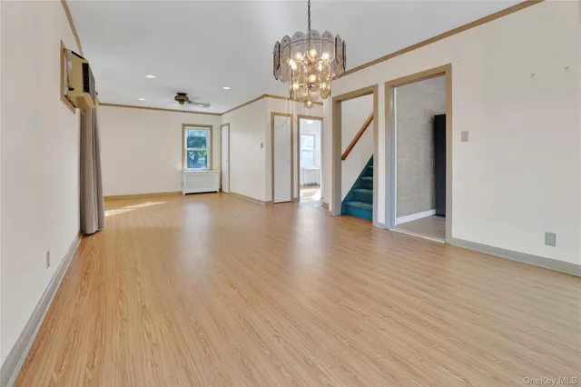 a view of a livingroom with wooden floor and staircase