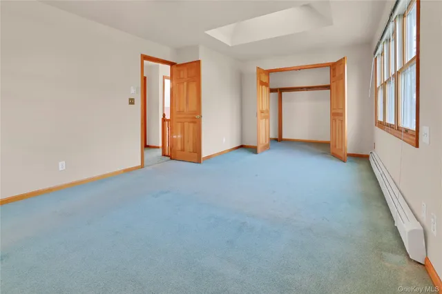 an empty room with windows and closet