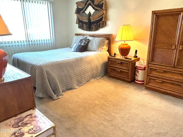 a bedroom with a bed and a flat tv screen on dresser