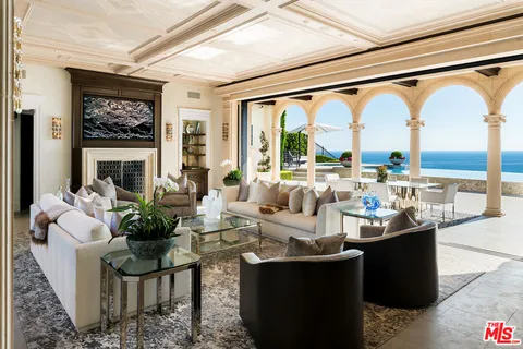 a living room with large windows and a table