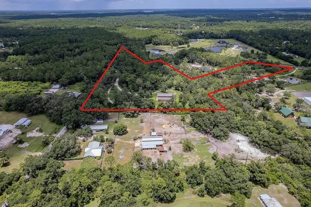 a aerial view of a houses with a yard and lake