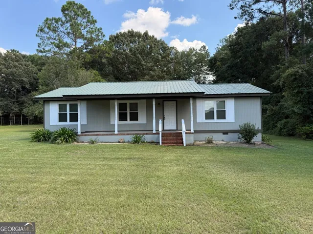 a backyard of a house with table and chairs