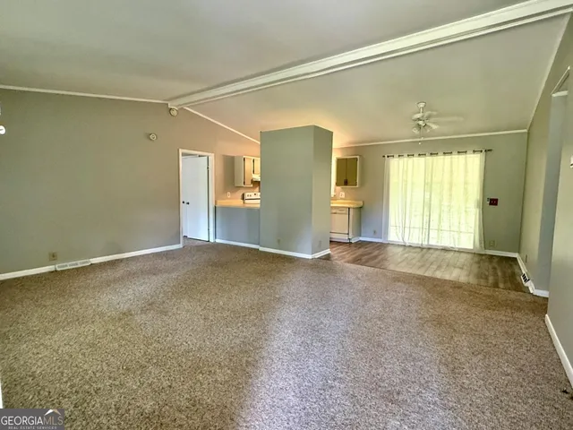 a view of a big room with windows and chandelier fan