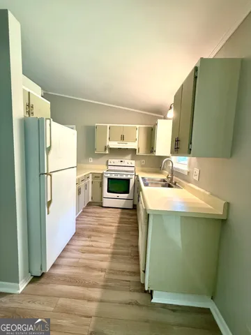 a kitchen with a sink refrigerator and a microwave