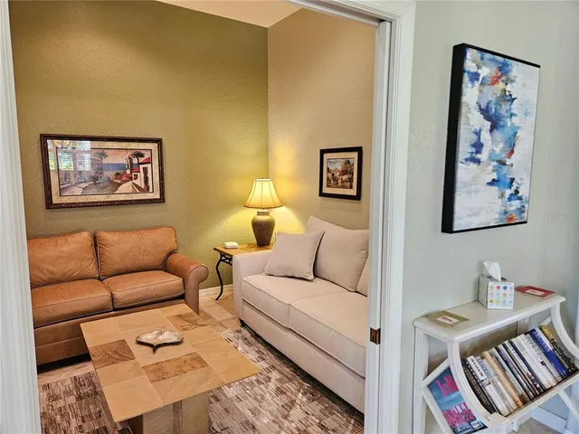 a living room with furniture and a baby crib