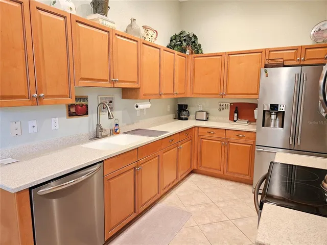 a kitchen with stainless steel appliances a sink a refrigerator and cabinets
