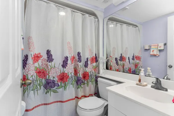 a bathroom with a sink vanity mirror and toilet