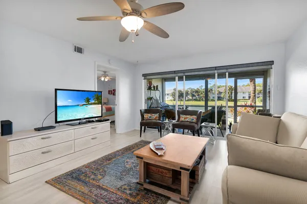a living room with furniture a flat screen tv and a large window