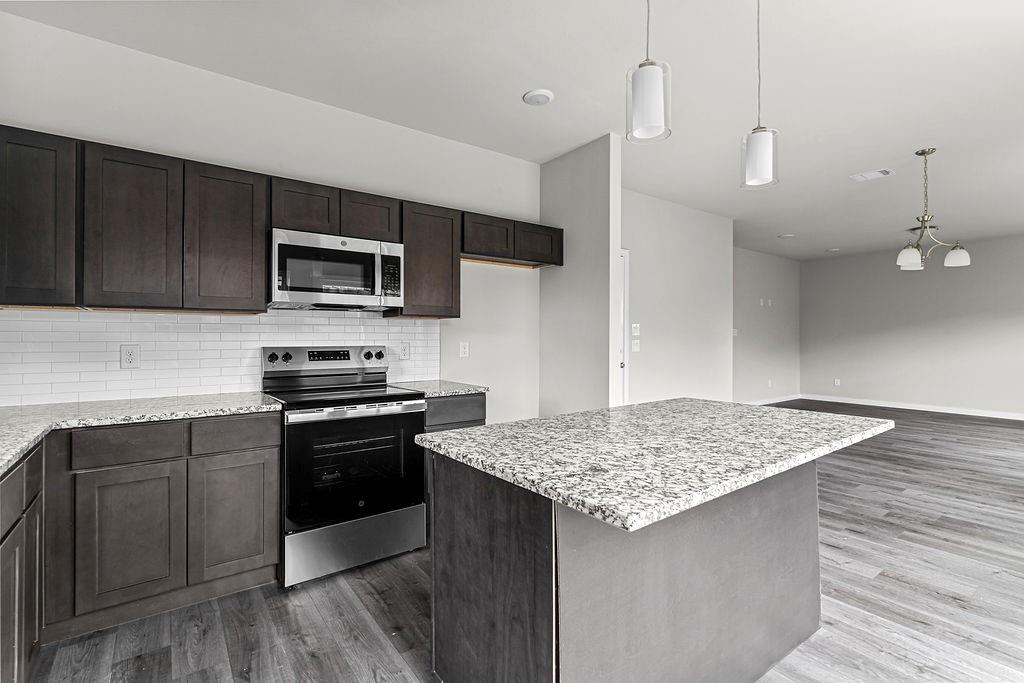 620 Alameda Road Azle, TX 76020 - Photo 7 of 27 a kitchen with kitchen island granite countertop stainless steel appliances and wooden cabinets