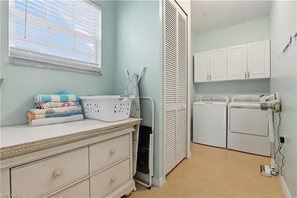a utility room with cabinets washer and dryer