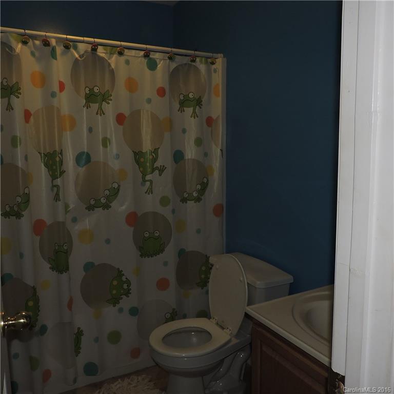 4594 Wylies Mill Road, Unit 1 Edgemoor, SC 29712 - Photo 7 of 11 a white toilet sitting next to a shower curtain