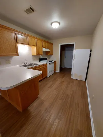 a kitchen with stainless steel appliances a sink a stove a refrigerator and cabinets