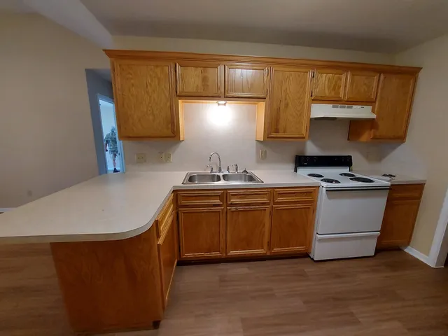a kitchen with granite countertop a sink a stove and cabinets