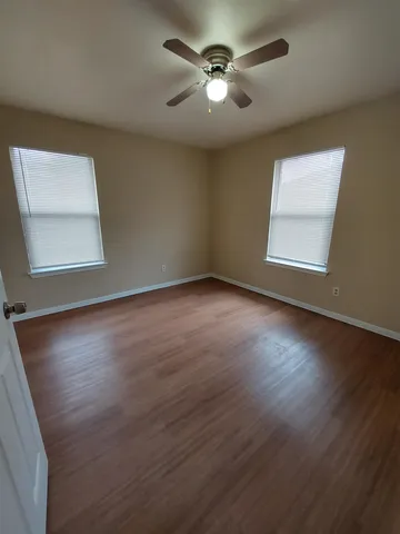 a view of room with hardwood floor and ceiling fan