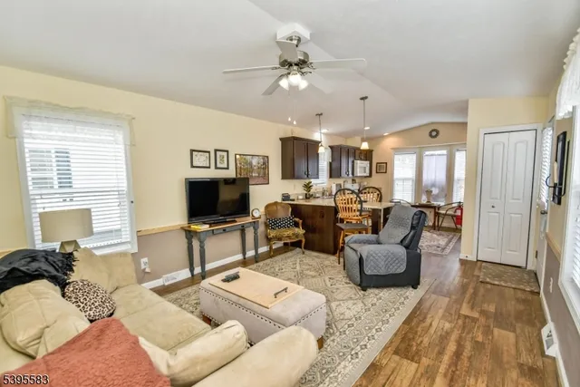 a living room with furniture kitchen view and a window