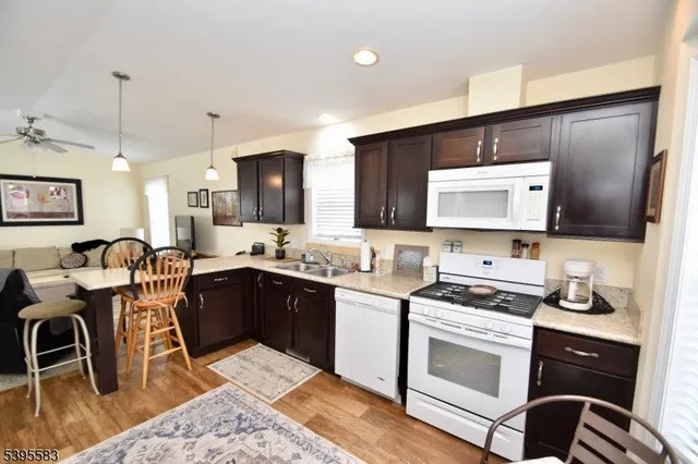 a kitchen with stainless steel appliances kitchen island granite countertop a sink cabinets and wooden floor