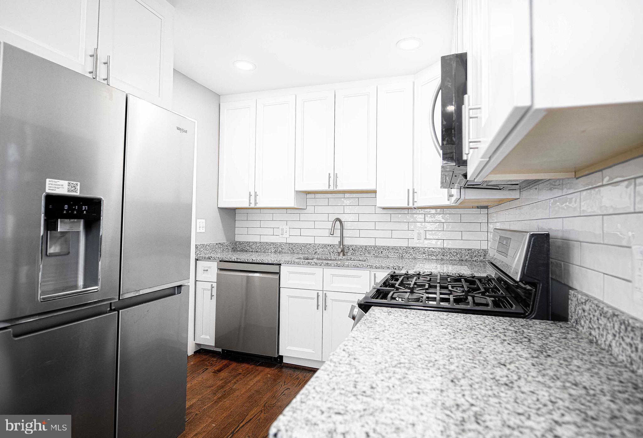 7906 31st Street Rosedale, MD 21237 - Photo 19 of 33 a kitchen with stainless steel appliances granite countertop a stove a refrigerator and a sink