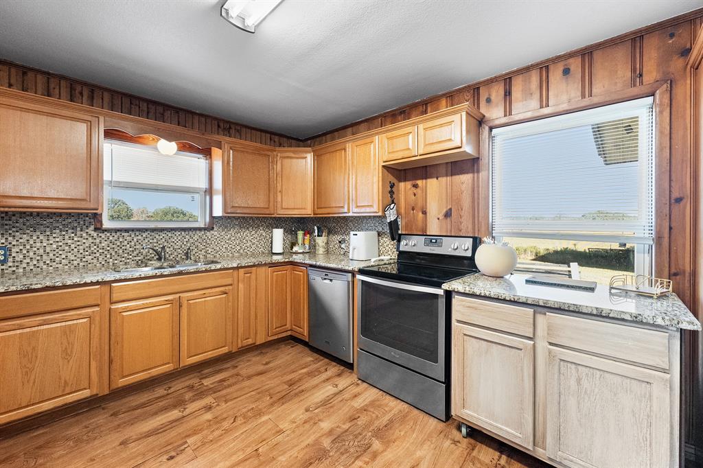 17215 Tarlton Road Mabank, TX 75147 - Photo 22 of 34 a kitchen with granite countertop wooden cabinets a sink and appliances