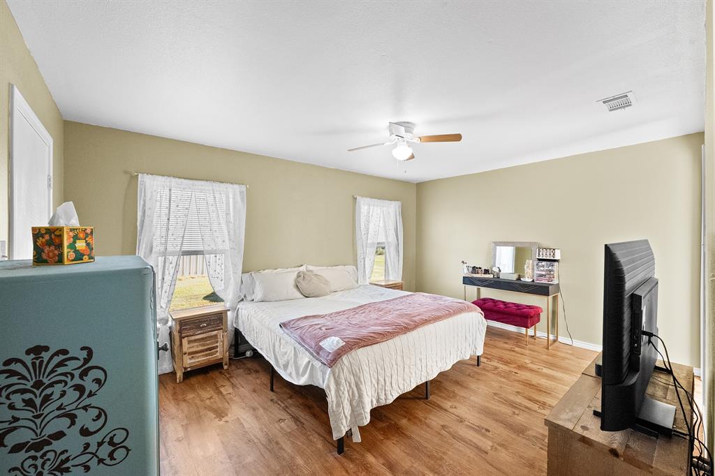 17215 Tarlton Road Mabank, TX 75147 - Photo 28 of 34 a bedroom with a bed and a dresser with wooden floor