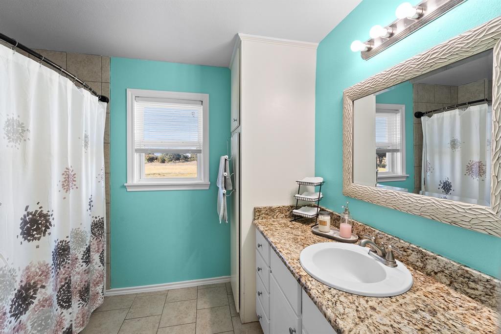 17215 Tarlton Road Mabank, TX 75147 - Photo 33 of 34 a bathroom with a granite countertop sink and a mirror