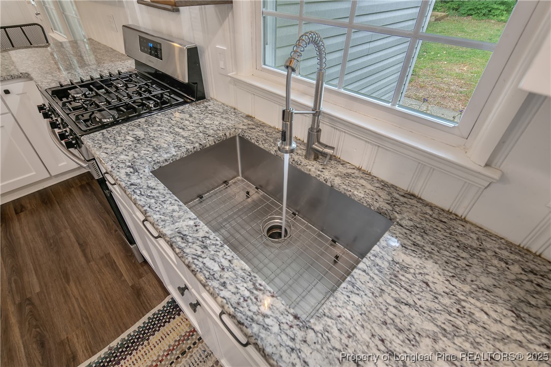 2615 Huntington Road Fayetteville, NC 28303 - Photo 21 of 47 a bathroom with a granite countertop sink and a stove