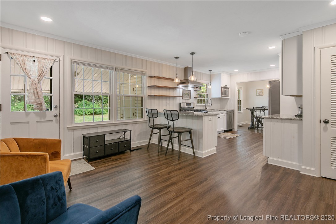 2615 Huntington Road Fayetteville, NC 28303 - Photo 24 of 47 a living room with stainless steel appliances furniture wooden floor and a kitchen view