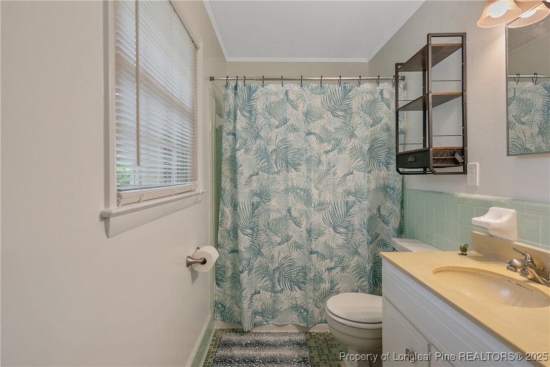 2615 Huntington Road Fayetteville, NC 28303 - Photo 32 of 47 a bathroom with a granite countertop toilet a sink and a shower