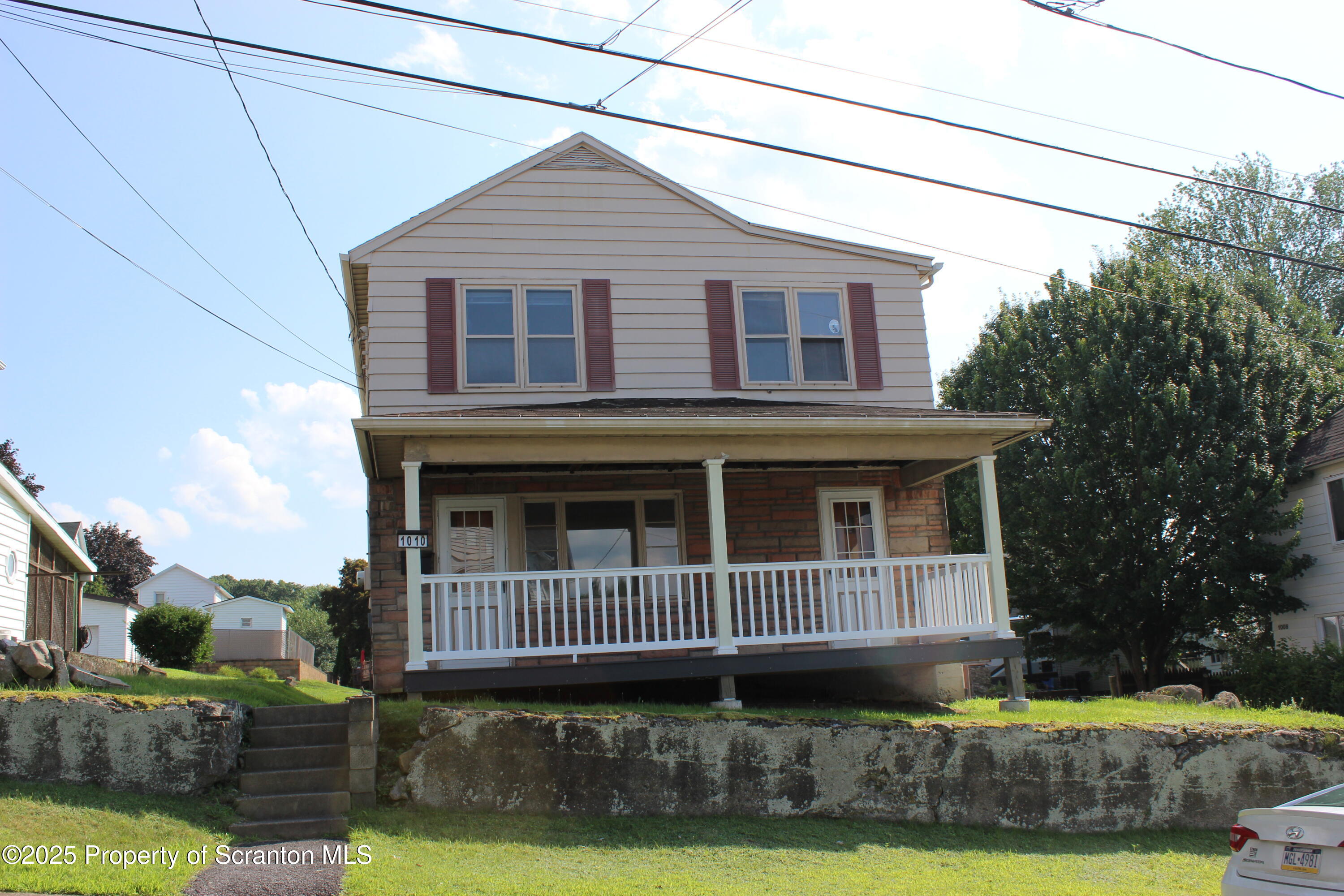 1010 McAlpine Street Avoca, PA 18641 - Photo 1 of 22 a view of a house with a small yard and large trees