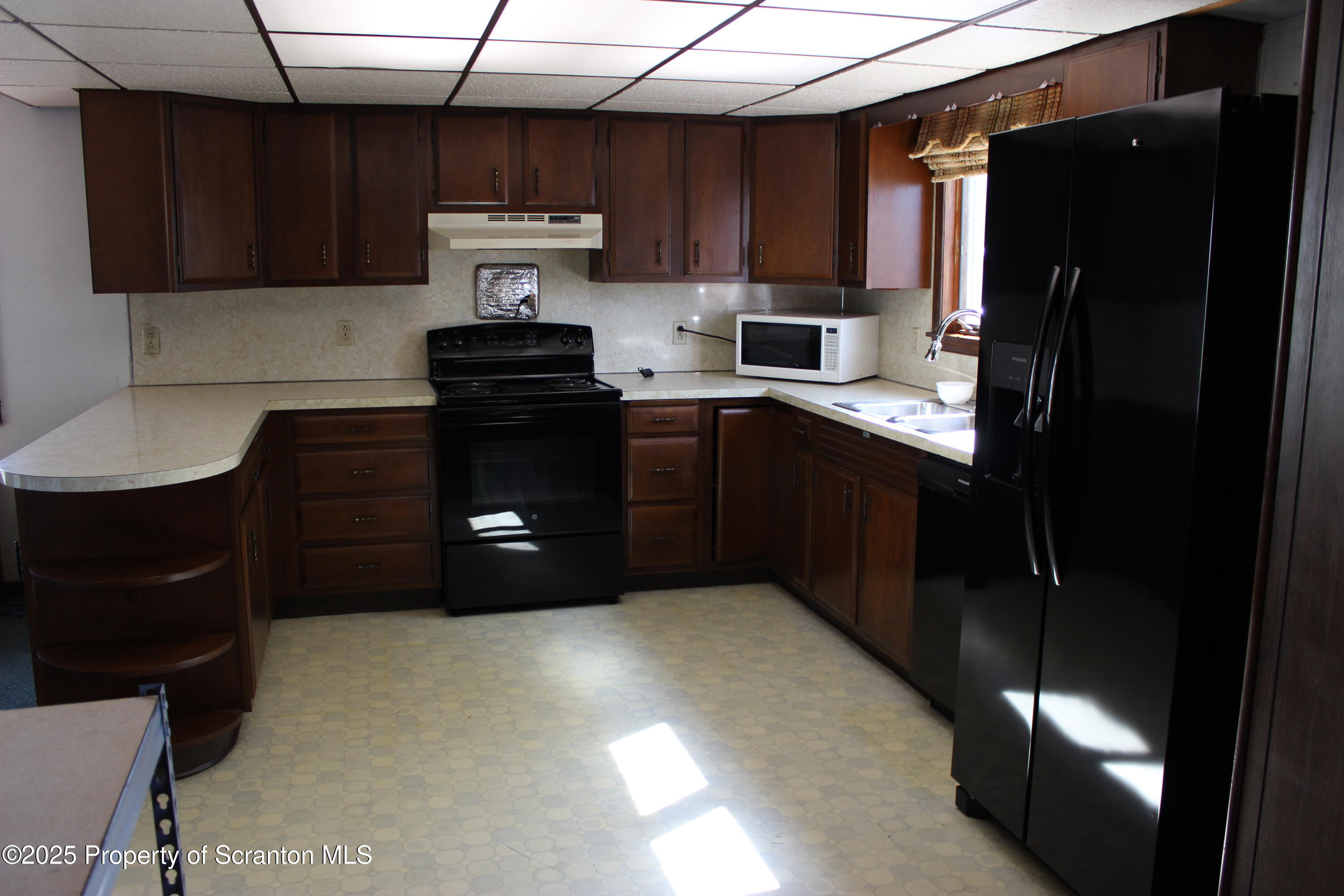 1010 McAlpine Street Avoca, PA 18641 - Photo 12 of 22 a kitchen with a refrigerator and a stove