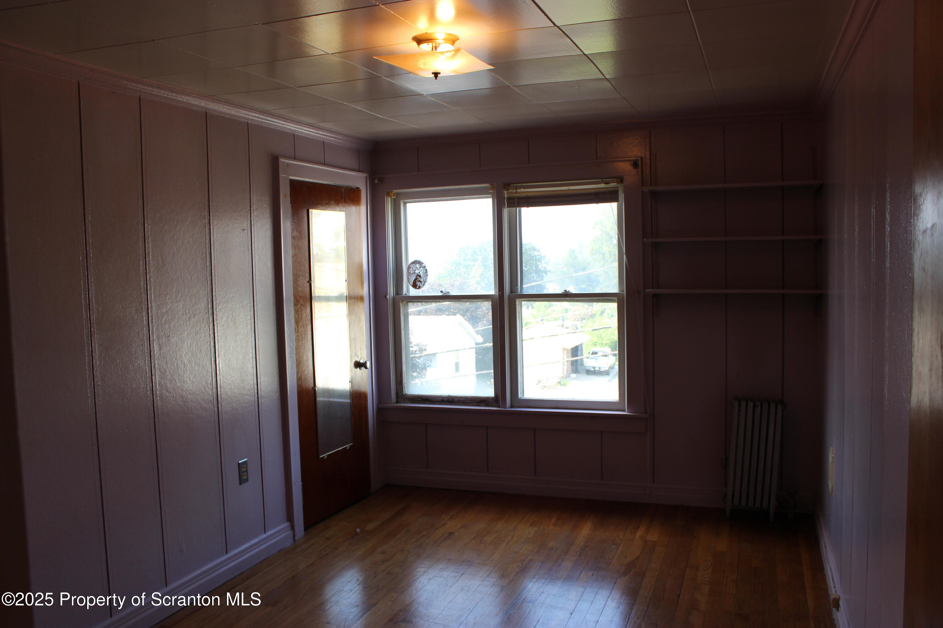 1010 McAlpine Street Avoca, PA 18641 - Photo 16 of 22 a view of an empty room with wooden floor and a window
