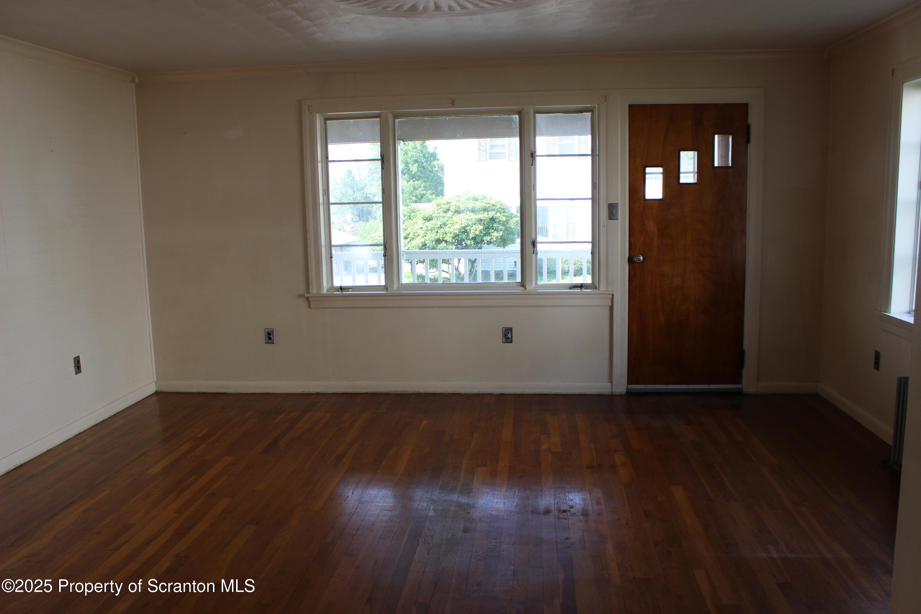 1010 McAlpine Street Avoca, PA 18641 - Photo 3 of 22 an empty room with wooden floor and windows