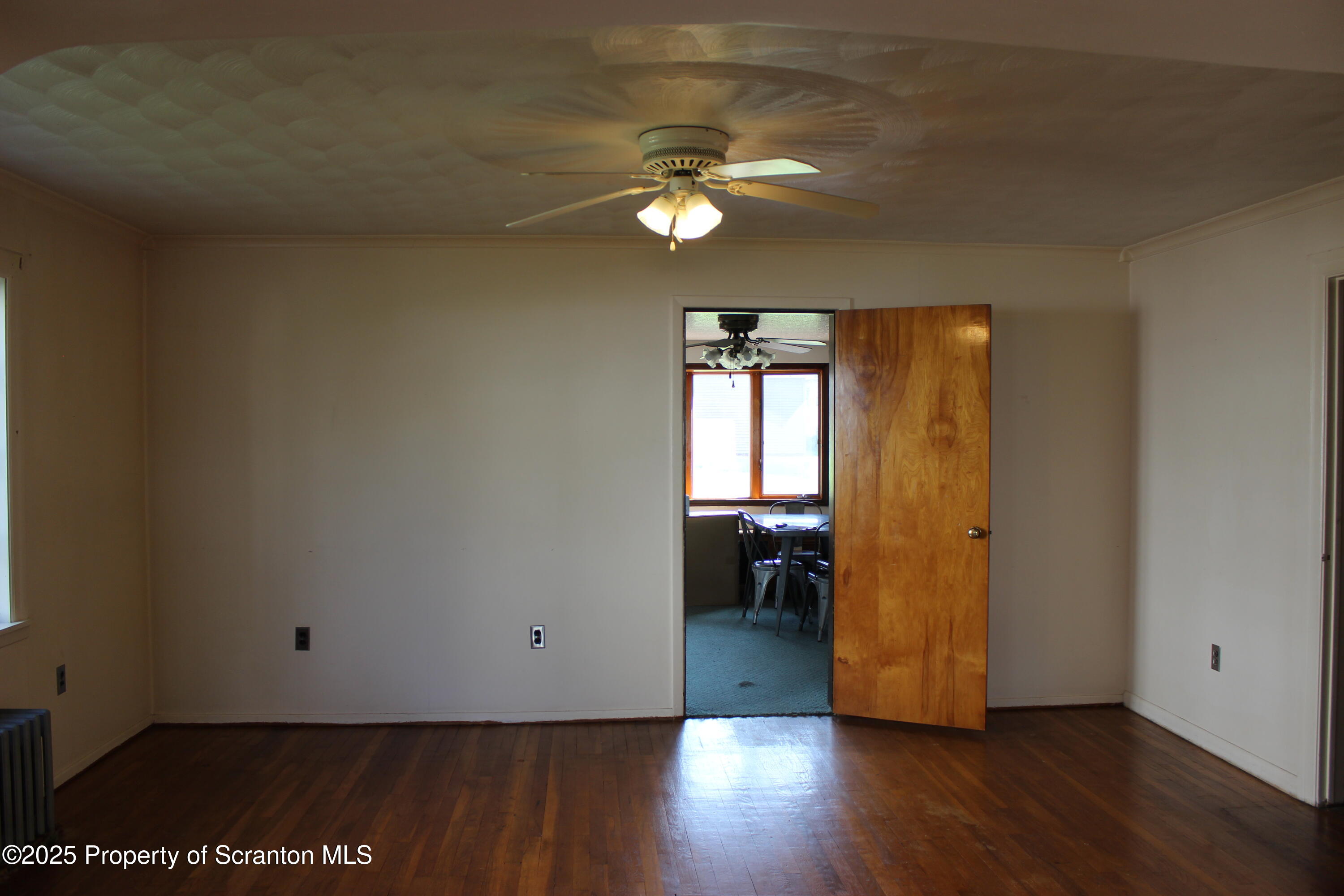 1010 McAlpine Street Avoca, PA 18641 - Photo 5 of 22 a view of a livingroom with a hardwood floor and a ceiling fan