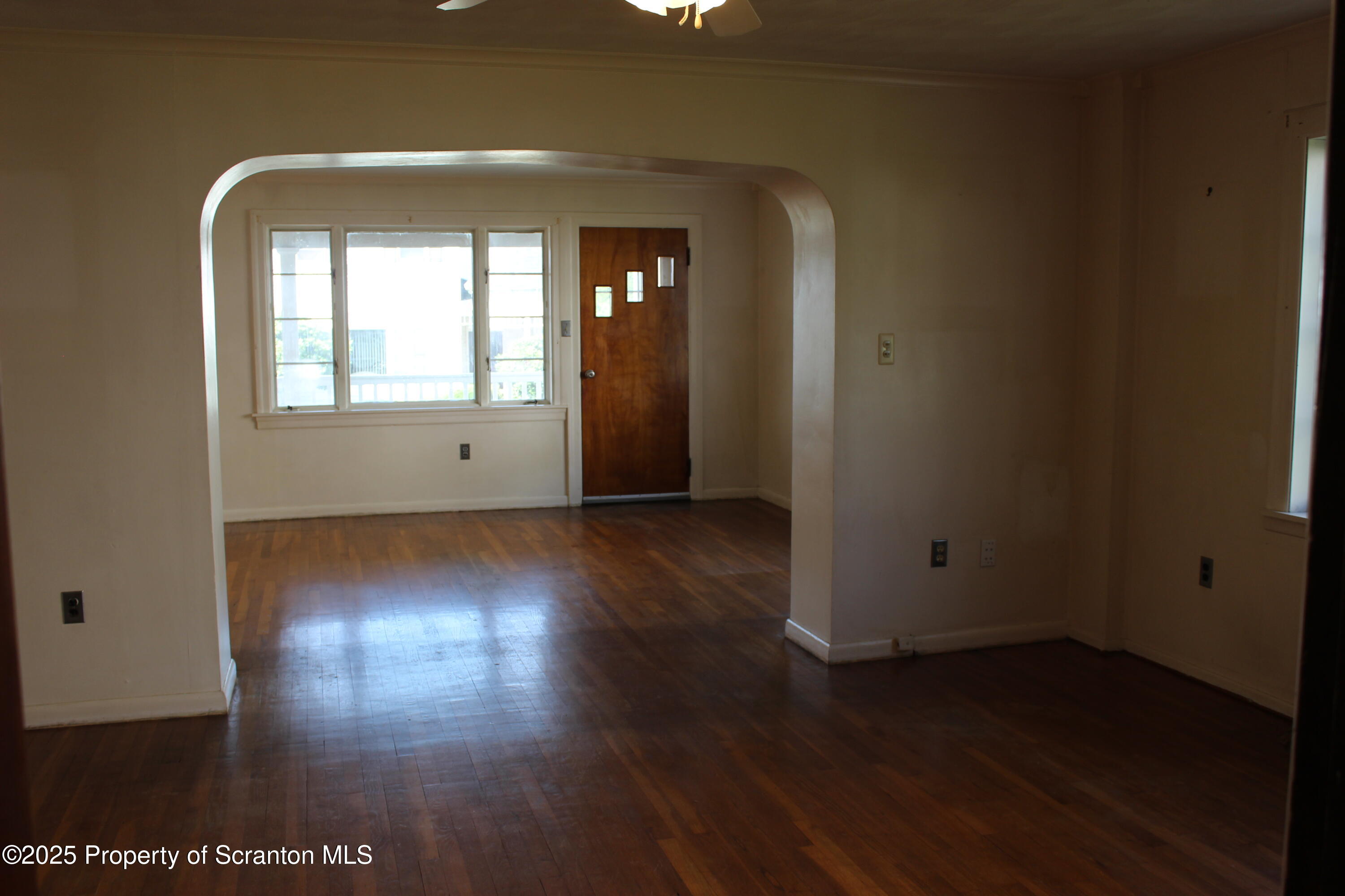 1010 McAlpine Street Avoca, PA 18641 - Photo 8 of 22 an empty room with wooden floor and windows