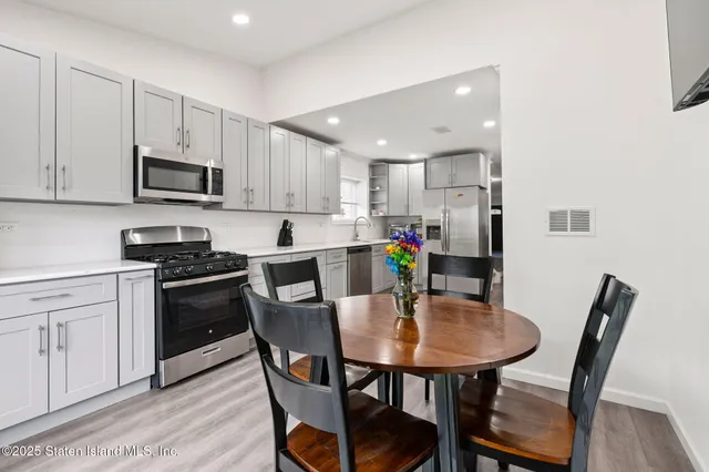 a kitchen with a dining table chairs microwave and cabinets