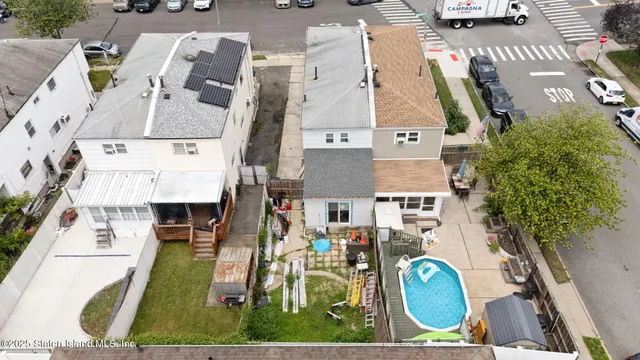 an aerial view of residential houses with outdoor space and parking