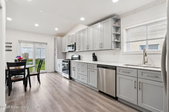 a kitchen with white cabinets and sink