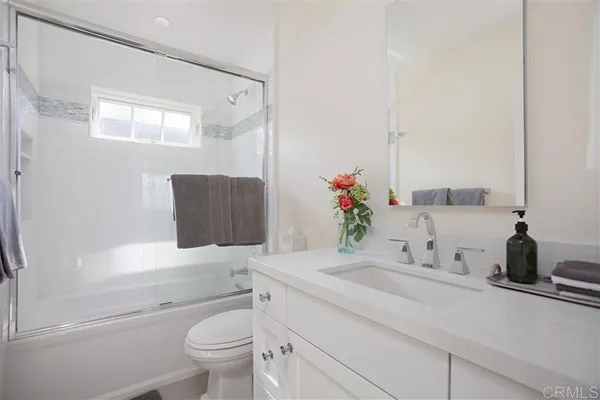 a bathroom with a granite countertop sink a toilet and a mirror