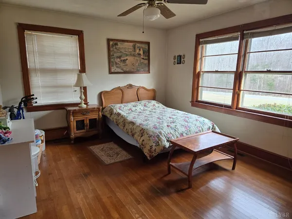 a bedroom with a bed a dresser and a window