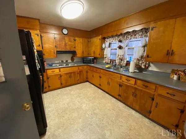 a large kitchen with stainless steel appliances granite countertop a sink stove and refrigerator