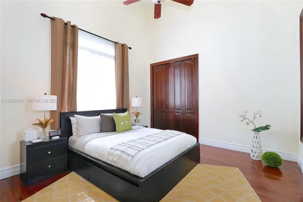 a bedroom with a bed potted plant with the dresser