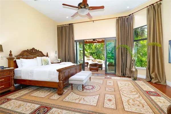 a bedroom with a bed a flat screen tv and a large window with outer view