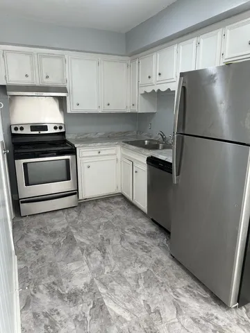 a kitchen with a refrigerator sink and cabinets