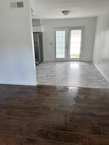 an empty room with wooden floor and windows
