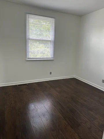 a view of a room with wooden floor and windows