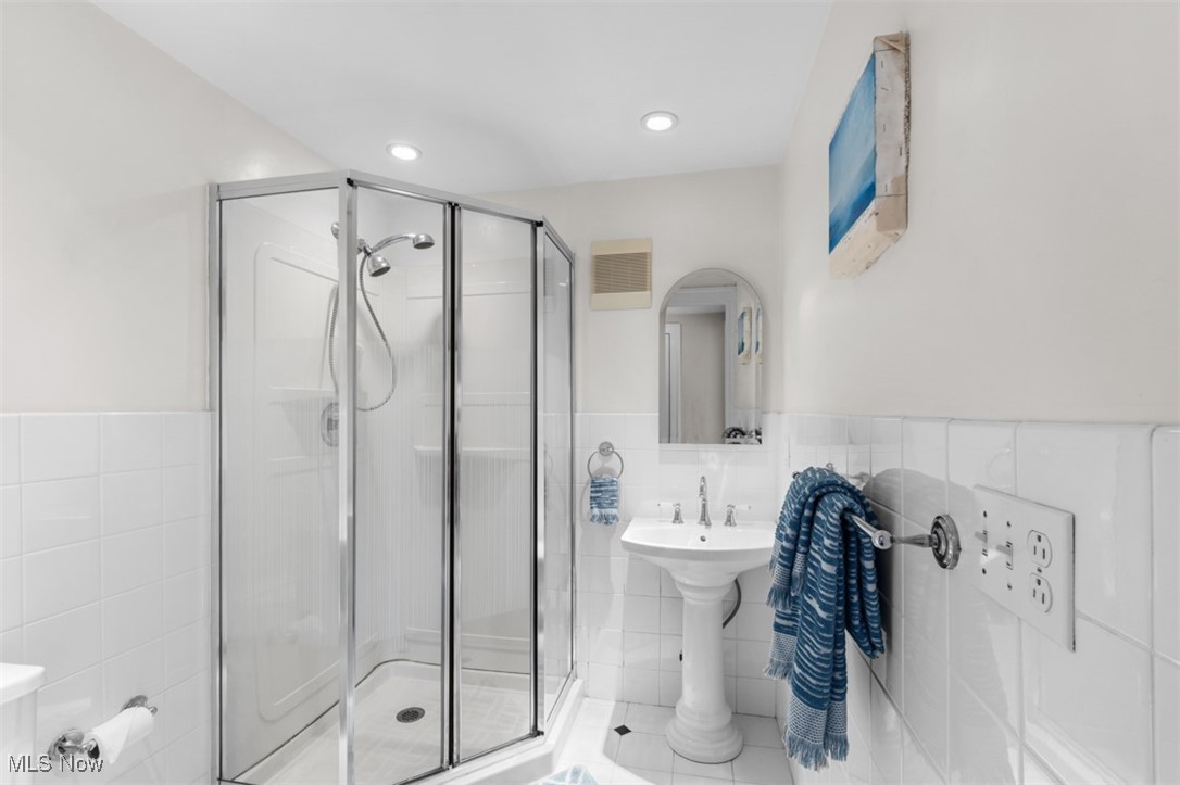 3124 Warrington Road Cleveland, OH 44120 - Photo 27 of 36 Full bath featuring tile walls, visible vents, a stall shower, and wainscoting