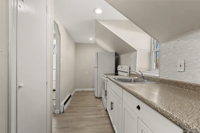 a bathroom with a granite countertop double vanity sink and mirror