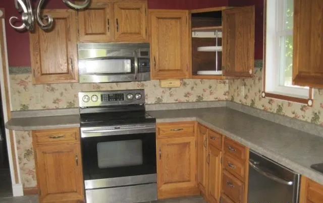 a kitchen with granite countertop a sink stove and cabinets