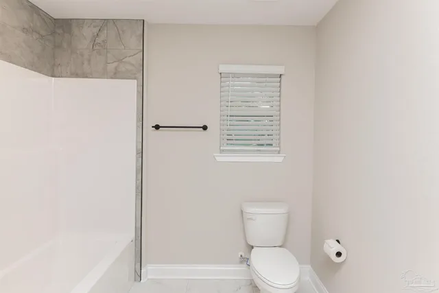 a white toilet sitting next to a bathroom sink