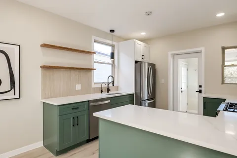 a kitchen with a sink refrigerator and cabinets