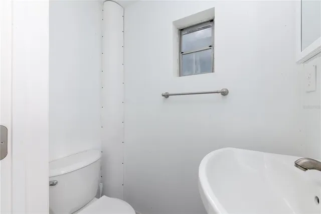 a bathroom with a white toilet and sink